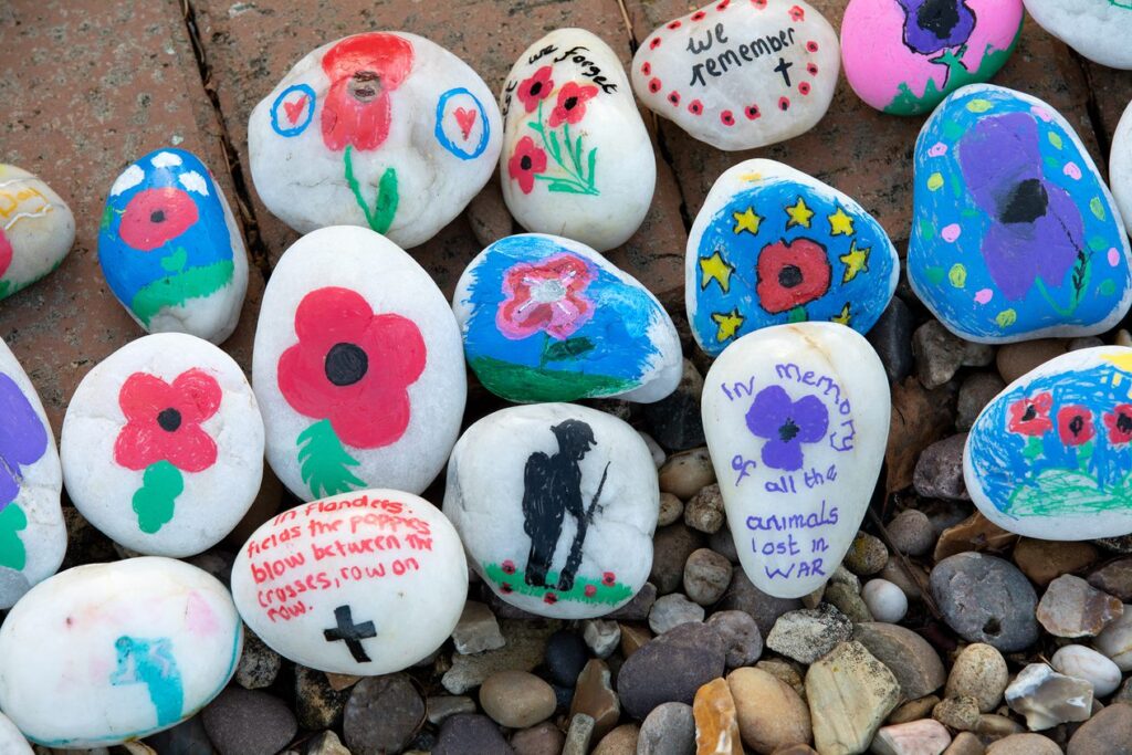 A selection of stones decorated with poppy and remembrance designs