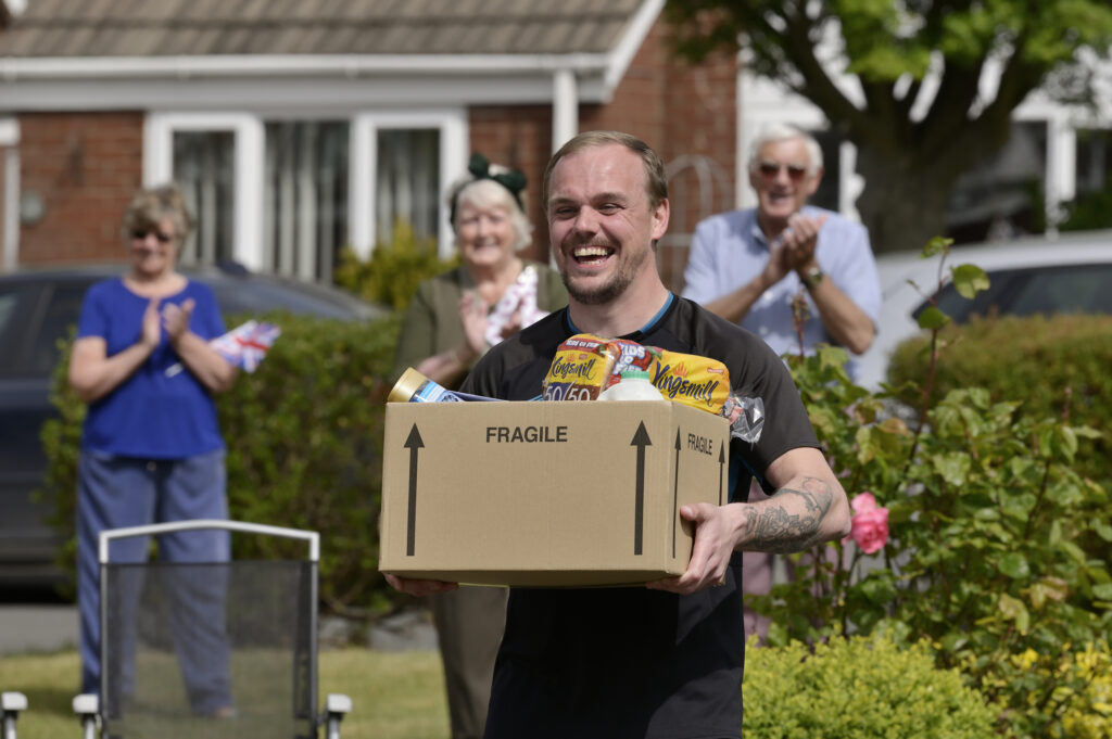 A man carries a box of food supplies