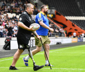 Veterans from Leeds Rhinos and Hull FC walk out with the match ball prior to a match.