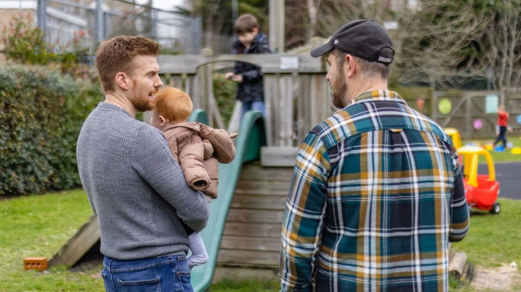 Two male parents in a playground