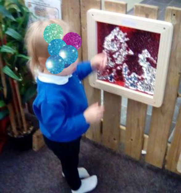 Child at Catterick Garrison Pre school playing with a toy outside